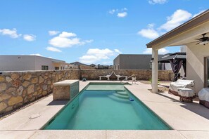 A swimming pool with a stone wall and a covered patio area. - The Gibraltar Retreat at Red Hawk (Las Cruces)