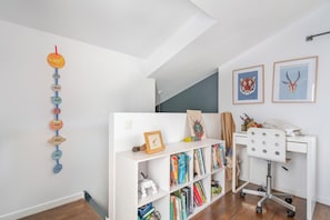 A room with a white desk, a bookshelf, and a wall-mounted decoration. - Spacious architect-designed home, perfect for families—near Disneyland and Paris (Montreuil)