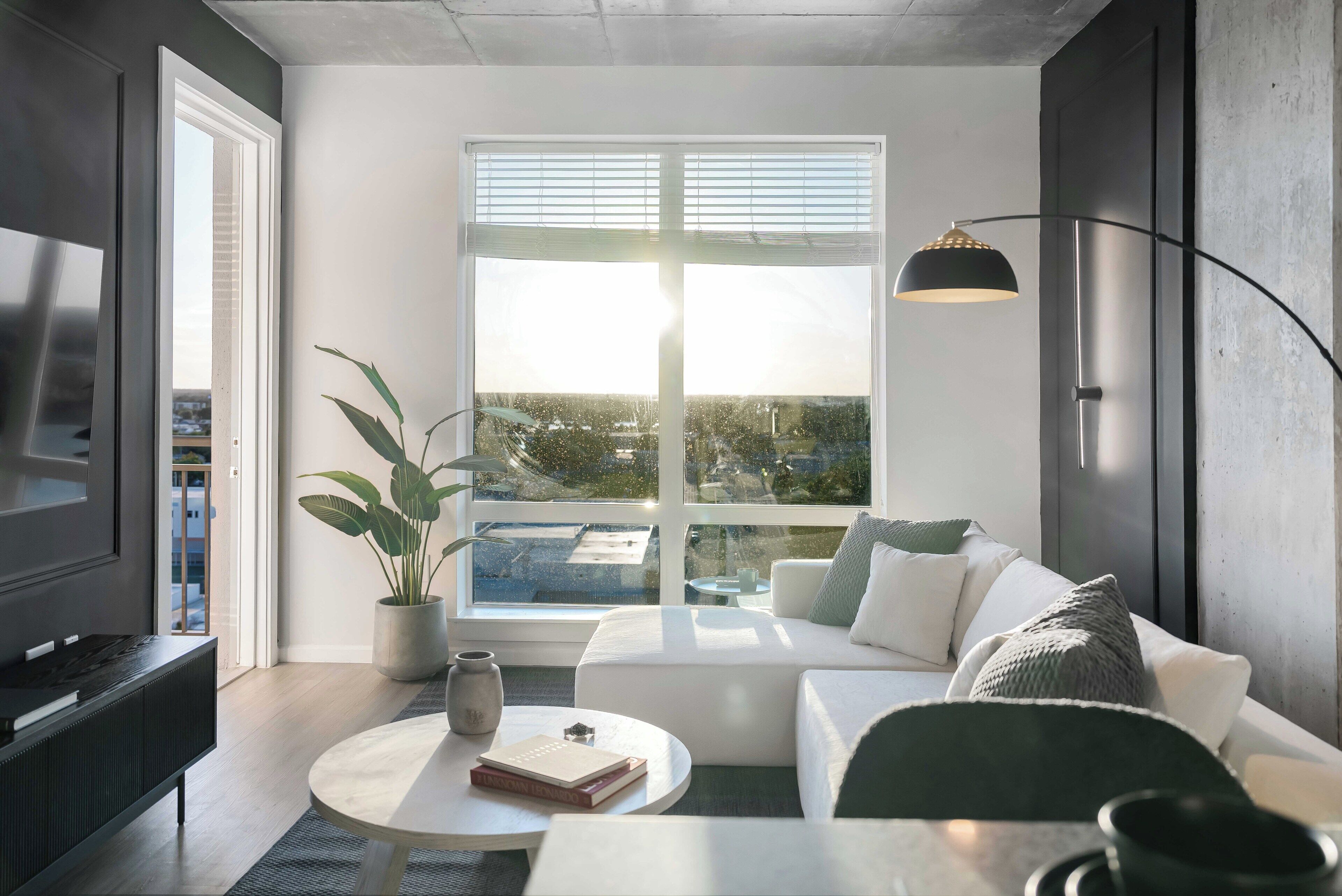 Un salon moderne avec un canapé, une table basse et un téléviseur.