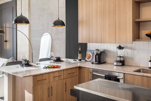 Eine moderne Küche mit Holzschränken, einer Granit-Arbeitsplatte und Edelstahlgeräten.