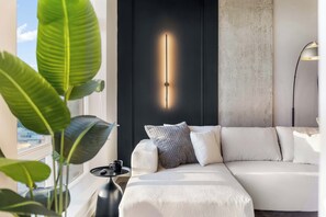 Ein modernes Wohnzimmer mit einem weißen Sofa, einer schwarzen Akzentwand und einer Stehlampe.