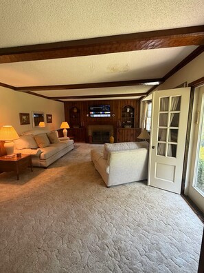 A cozy living room with a fireplace, two sofas, and a television. - High-Acres  3-bedroom house with AC in cozy Coshocton (Coshocton)