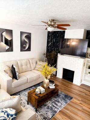 Una sala de estar moderna con sofá, mesa de centro y chimenea.