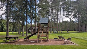 A playground with a slide, swing set, and picnic table. - Eagle's Nest On The Water (Butternut)