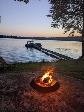 A lakeside setting with a dock, a fire pit, and a tree. - Musky Haven Lake Veiws (Butternut)