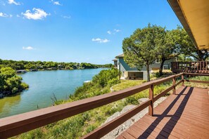 Eine Holzterrasse mit Blick auf einen Fluss und Häuser im Hintergrund.