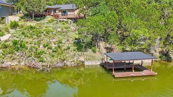 A lakeside property with a wooden deck and a small pavilion.