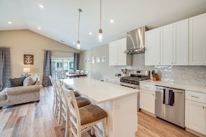 A modern kitchen with white cabinetry, a central island, and stainless steel appliances. - Fantastic 4-bedroom condo - Walk to the Beach! (Wildwood)