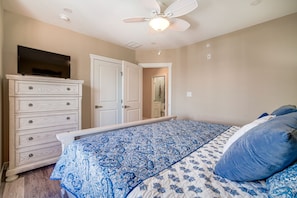 A bedroom with a bed, dresser, ceiling fan, and a TV on the dresser. - Fantastic 4-bedroom condo - Walk to the Beach! (Wildwood)