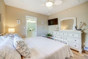 A bedroom with a large bed, a dresser, a mirror, and a ceiling fan. - Fantastic 4-bedroom condo - Walk to the Beach! (Wildwood)