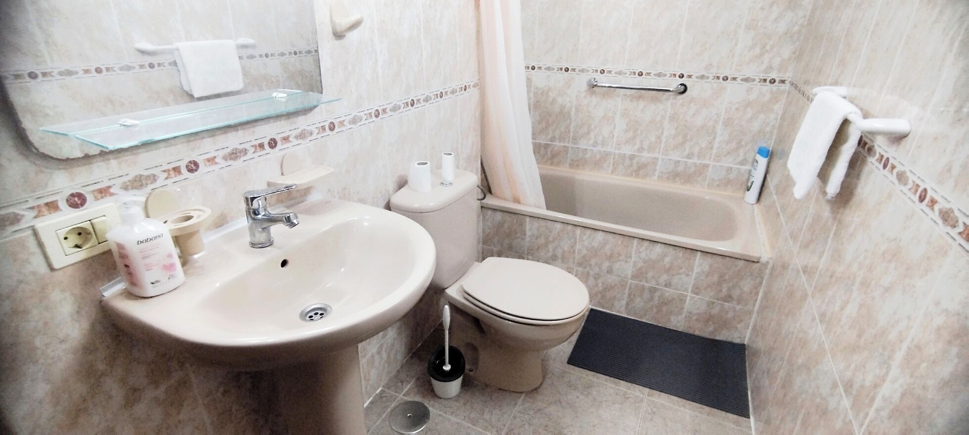 A bathroom with a sink, toilet, and bathtub.