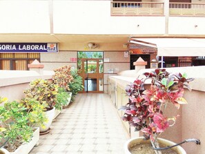 Une entrée d'immeuble avec une enseigne indiquant « SORIA LABORAL » et une porte donnant sur un espace abrité.