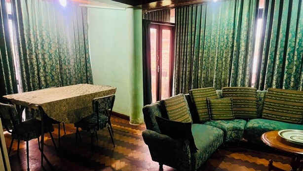 A room with a dining table, chairs, a sofa, and a patterned floor. - Centrally Located, Fully Furnished Apartment with Support Services and Close to Everything! (Tarija)