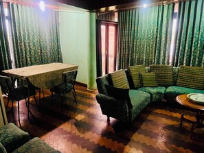 Habitació amb taula de menjador, cadires, sofà i terra amb un disseny decoratiu.