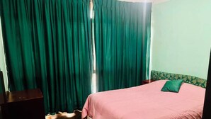 A room with a bed, a desk, and a window with curtains. - Centrally Located, Fully Furnished Apartment with Support Services and Close to Everything! (Tarija)