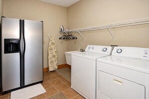 A laundry area with a stainless steel refrigerator, a washing machine, and a dryer. - Kumbaya House: Steps from Cupp Run | Hot Tub, Deck & Epic Sunset Views (Snowshoe)