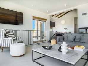 A modern living room with a sofa, chairs, a coffee table, and a balcony with a railing. - 5* Luxury Seaview Villa Plant 4 with pool by Interhome (Novalja)