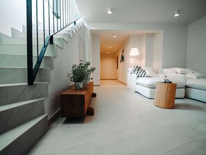 A modern interior with a staircase, a wooden table with a plant, a white sofa, and a lamp. - 5* Luxury Seaview Villa Plant 4 with pool by Interhome (Novalja)