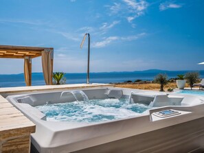 A hot tub with a wooden deck and a pergola, overlooking a body of water and distant mountains. - 5* Luxury Seaview Villa Plant 3 with pool by Interhome (Novalja)