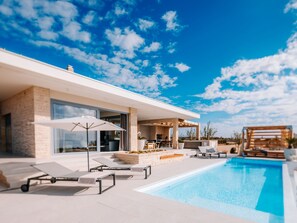 A modern house with a swimming pool, outdoor furniture, and a patio area. - 5* Luxury Seaview Villa Plant 3 with pool by Interhome (Novalja)