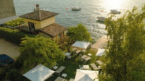 Una propiedad junto al lago con comedor, asientos al aire libre y barcos en el agua.