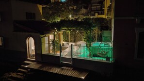 Un edificio residencial con balcón, jacuzzi y un pequeño jardín.