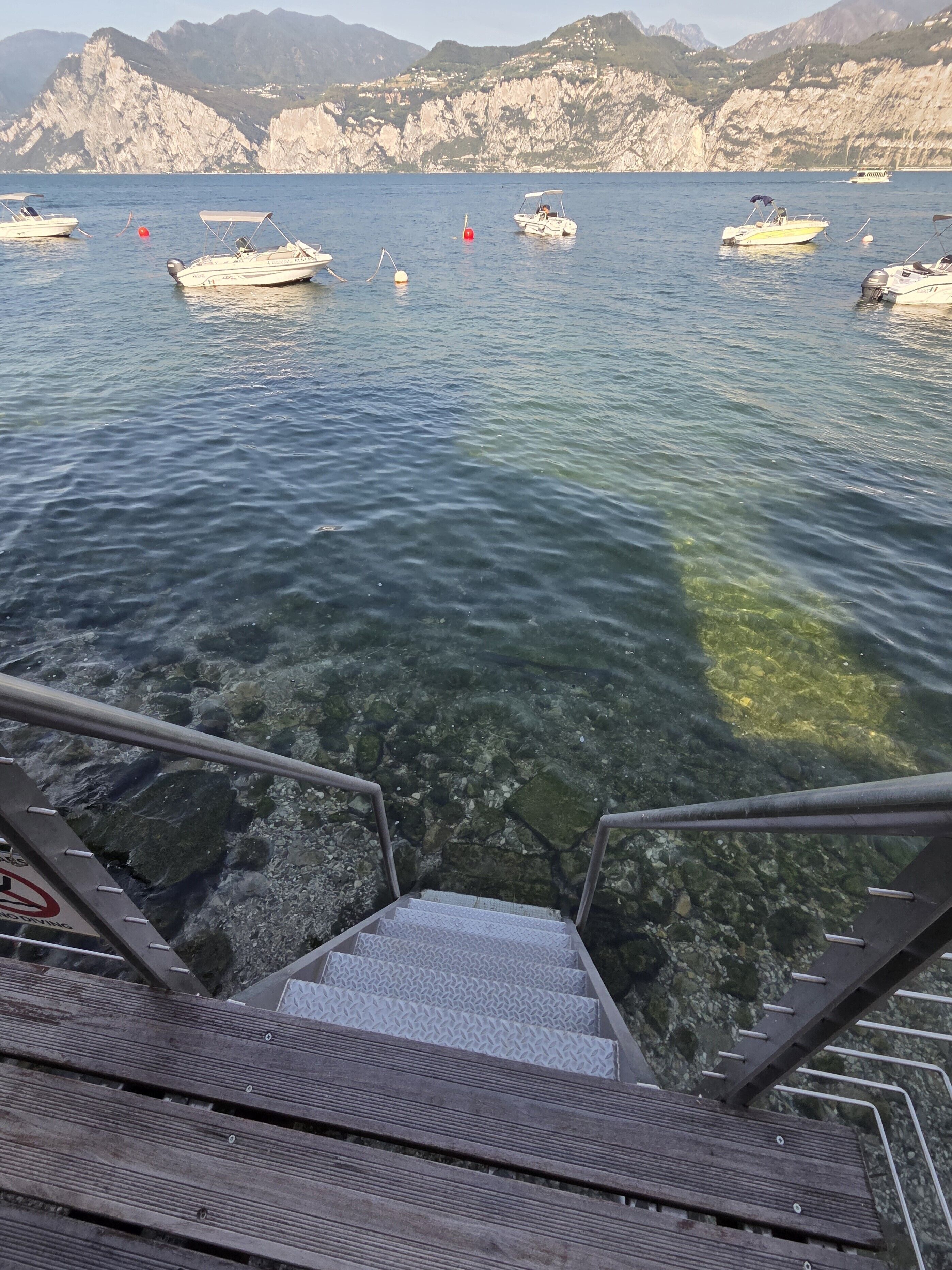 A clear view of a boat dock with steps leading down to the water, surrounded by rocky cliffs.