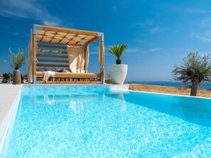 A clear blue pool with a wooden deck and a lounge chair. - 5* Luxury Seaview Villa Plant 5 with pool by Interhome (Novalja)