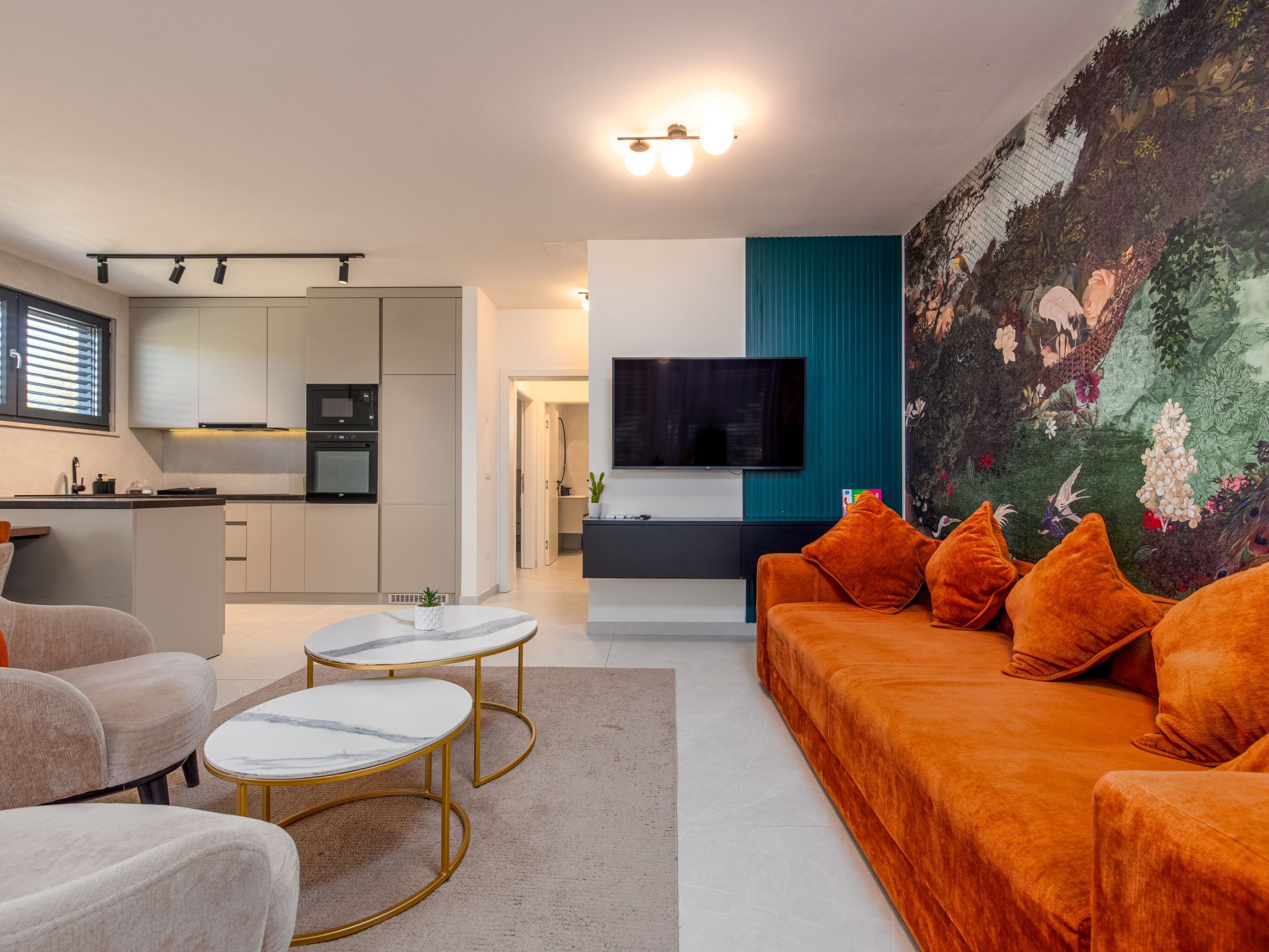 Een moderne woonkamer met een bank, twee salontafels en een televisie.