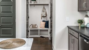 A hallway with a bench, a backpack hanging, and a shoe rack. - E. Nash 3BR Escape | Walkable | Family Friendly (Nashville)