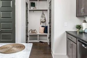 A hallway with a bench, a backpack hanging, and a shoe rack. - E. Nash 3BR Escape | Walkable | Family Friendly (Nashville)