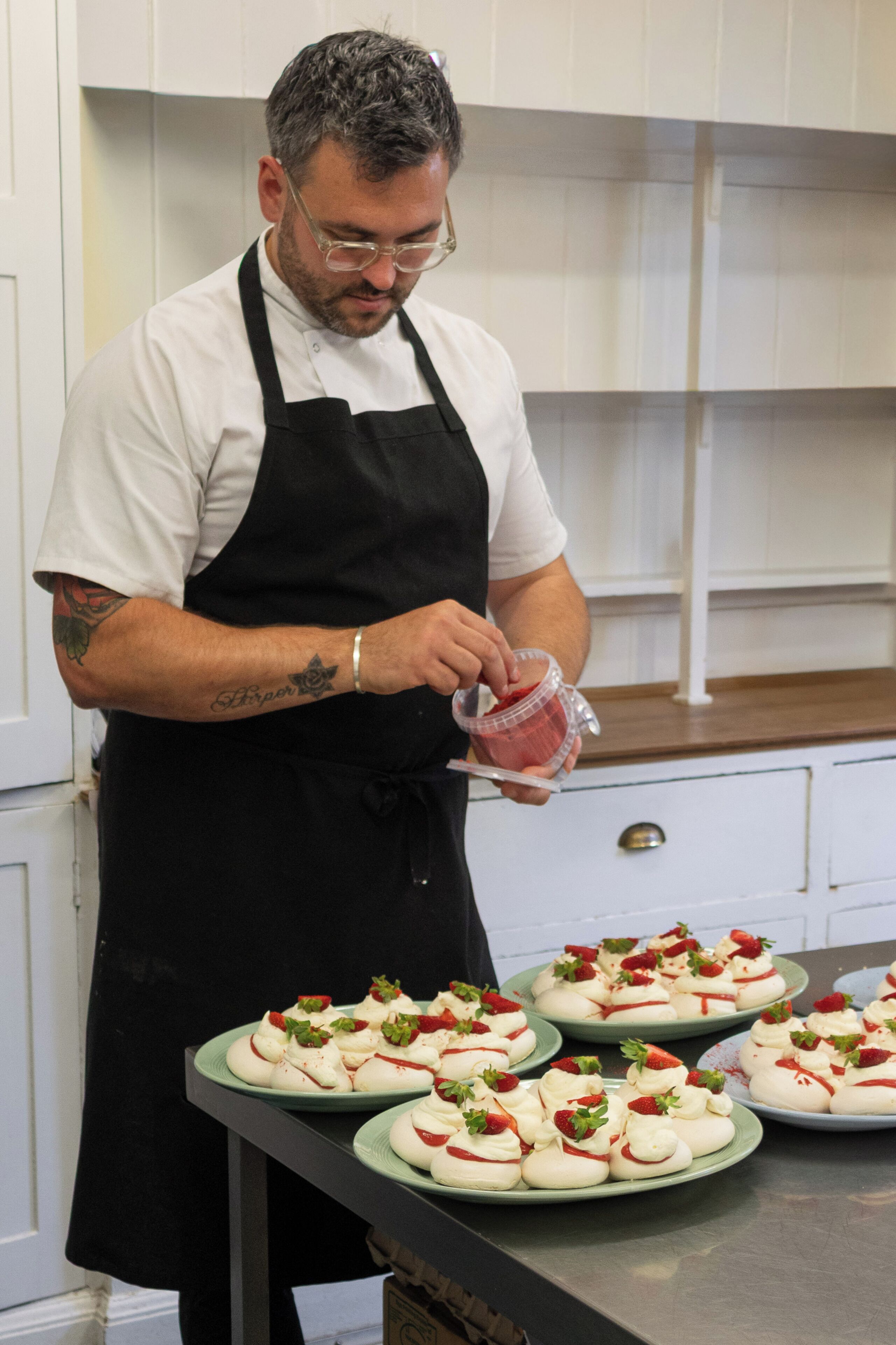 A person in a chef's uniform preparing food in a kitchen.