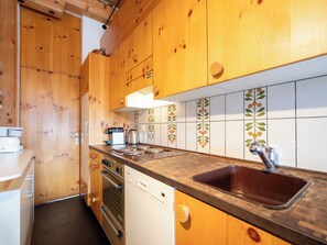 A kitchen with wooden cabinets, a stainless steel stove, and a sink.