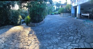A stone-paved courtyard with greenery and a building with outdoor seating. - Villa for 8–10 people in Lloret de Mar with a pool—6 km from the beach (CT)