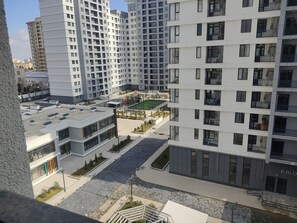 A modern high-rise building with multiple balconies, a rooftop area, and a central courtyard with a playground. - Baku Avant Park Premium (Baku)
