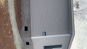 Kaksikerroksinen rakennus, jossa on harmaa katto, tiilestä tehty sokkeli ja sen sivussa numeroilla merkitty kyltti, jossa lukee ’968’.