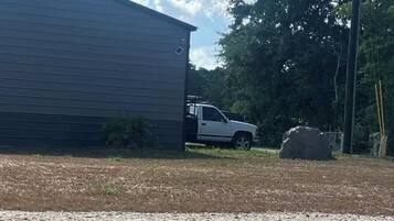 A gravel driveway leading to a building with a parked truck.