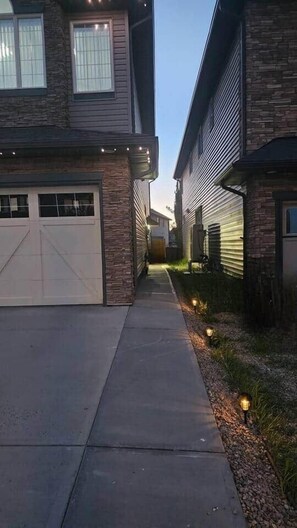 Une rue résidentielle bordée de maisons, avec des allées et un éclairage extérieur.