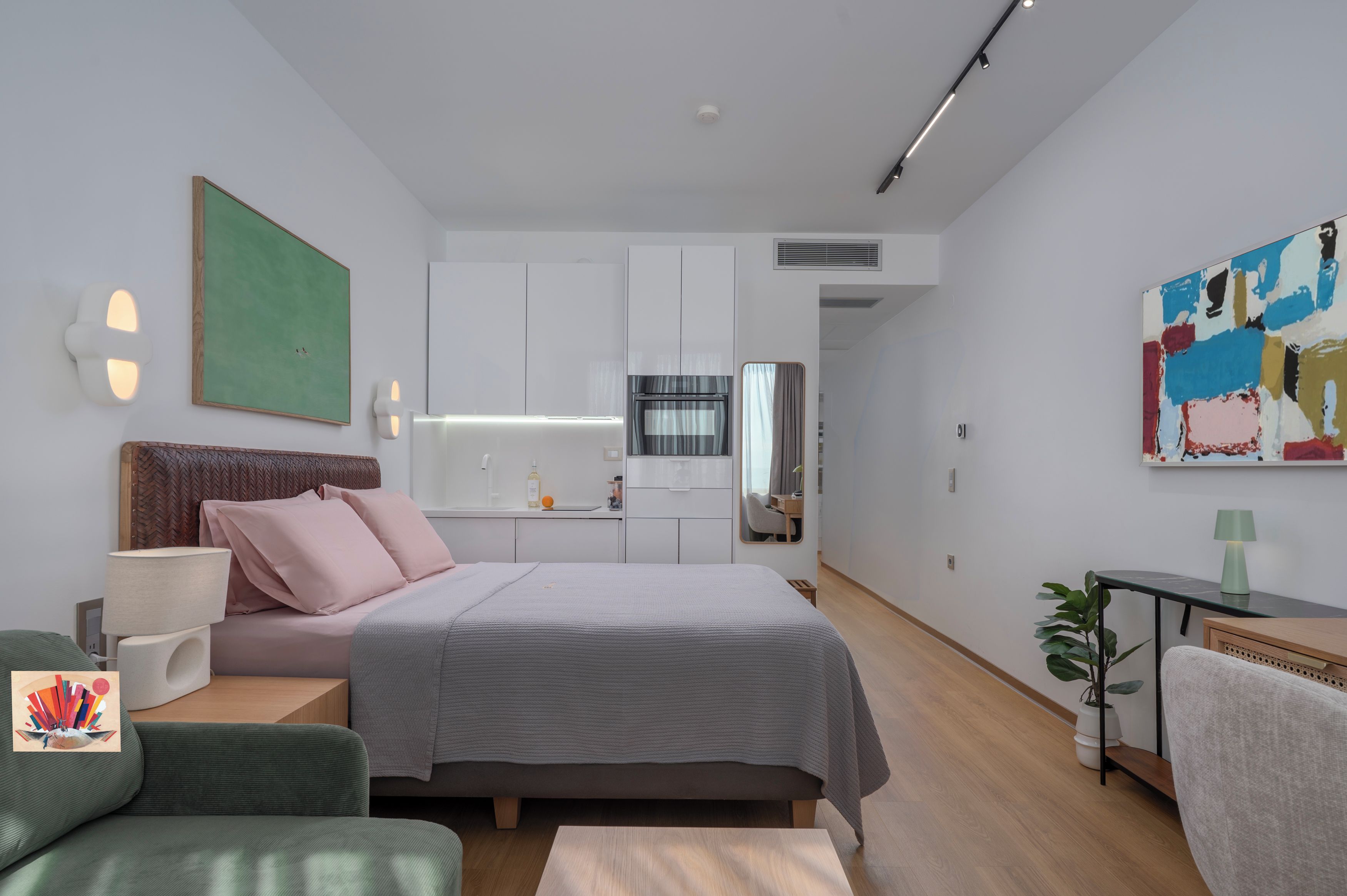 A modern bedroom with a bed, bedside table, lamp, and a painting on the wall.