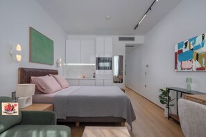 A modern bedroom with a bed, bedside table, lamp, and a painting on the wall. - Blue Elegant Suite (Thessaloniki)