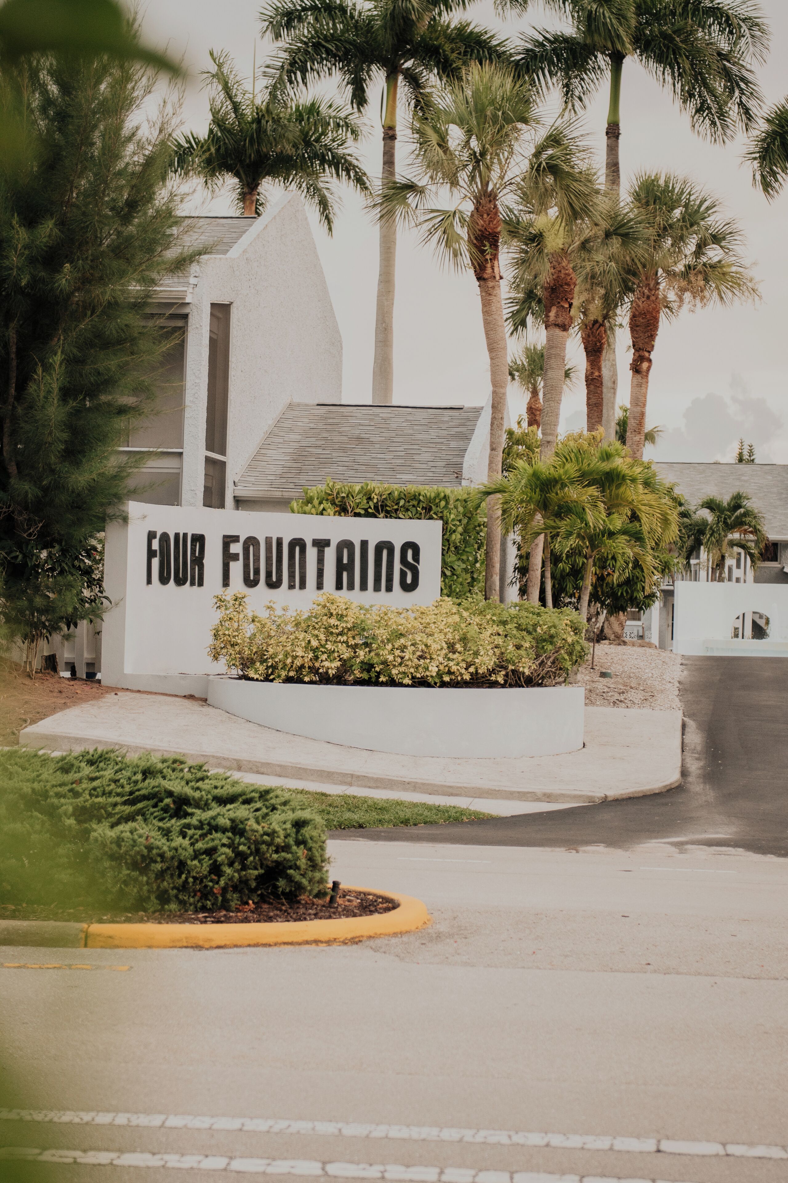 A sign for 'Four Fountains' with a modern building in the background.