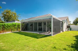Un espace extérieur abrité, doté d’une terrasse, de sièges et offrant une vue sur la végétation environnante.