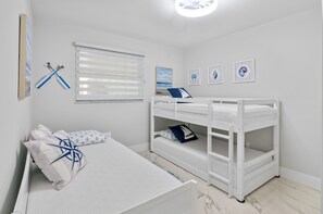 A child's bedroom with bunk beds, a window with blinds, and nautical-themed decorations. - Cozy 2-bedroom house in lovely Naples with private courtyard for relaxing stays. (Naples)