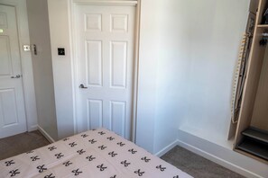Ein Zimmer mit einem Bett, einer Tür und einem Kleiderschrank.