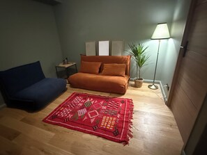 A room with a sofa, a red patterned rug, a lamp, and a small table. - Luxury Villa • Swimming Pool • View • Elevator (Falicon)