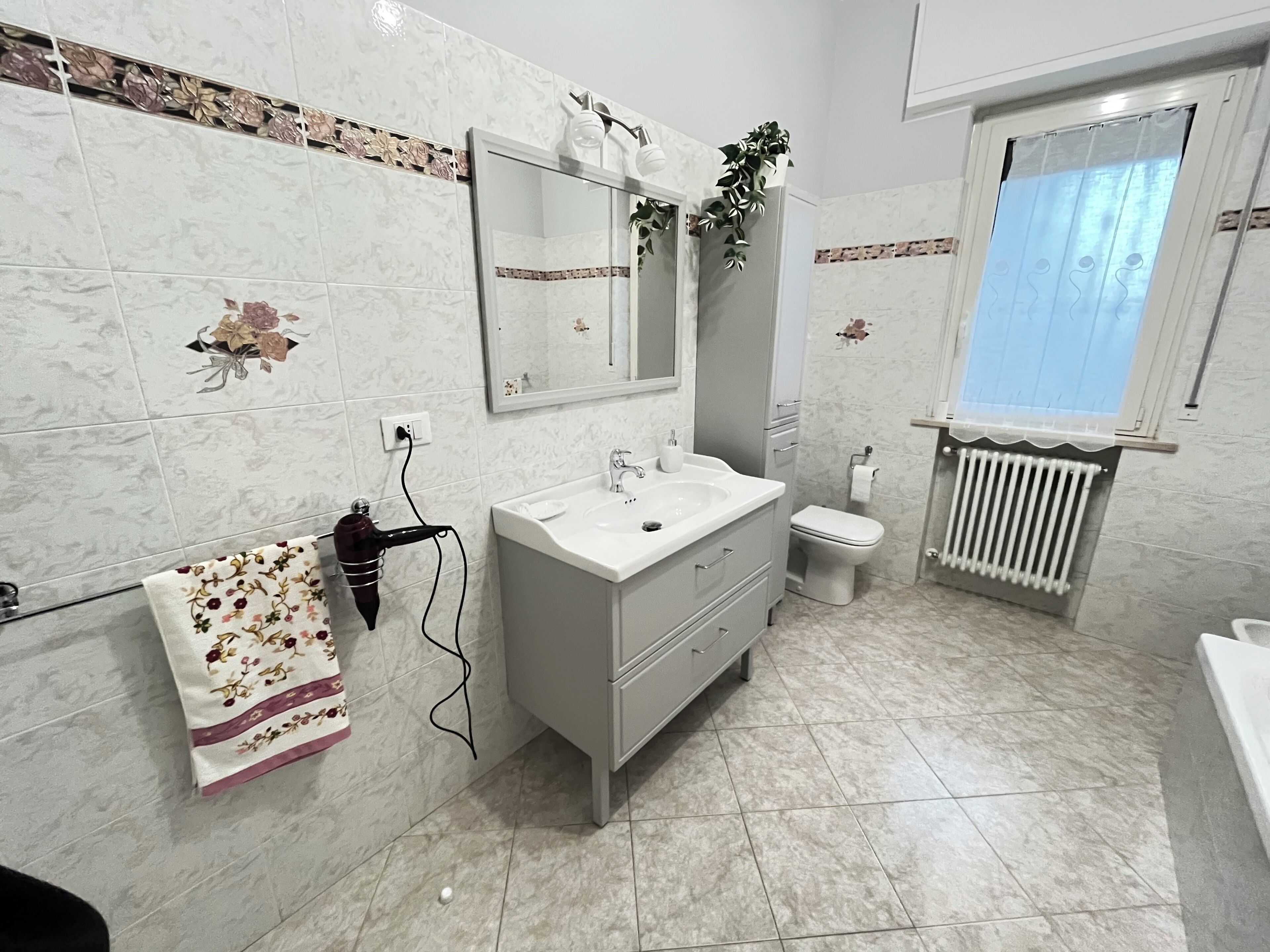 A bathroom with a white sink, mirror, and toilet.