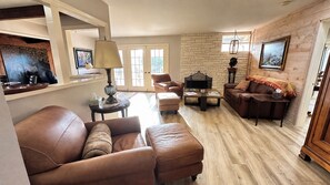 A living room with leather sofas, a coffee table, and a fireplace. - Bay Ho Retreat—Sleeps 9—5-Minutes to La Jolla, Pacific Beach, Bay & Trolley (San Diego)