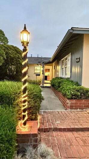 A pathway leading to a building with a number 4038 sign, a lamp post with spiral lights, and well-maintained hedges. - Bay Ho Retreat—Sleeps 9—5-Minutes to La Jolla, Pacific Beach, Bay & Trolley (San Diego)