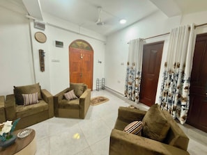 A living room with two sofas, a coffee table, and a door with curtains.