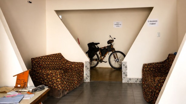 Una escalera conduce a un nivel inferior, con una bicicleta apoyada en la pared.